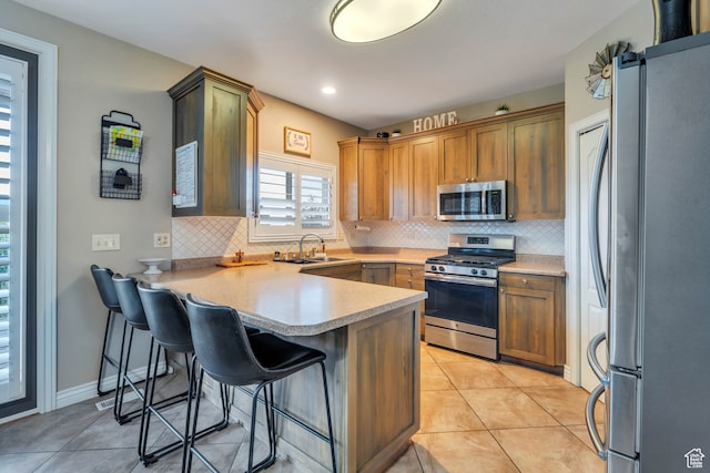 1122 Ironwood Rd, Erda, UT 84074 - kitchen featuring kitchen peninsula, stainless steel appliances, decorative backsplash, and a breakfast bar