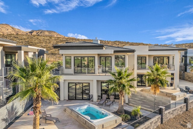 1498 W Torrey Pines Rd, Hurricane, UT 84737 - rear view of property with stucco siding, an outdoor hot tub, and a mountain view