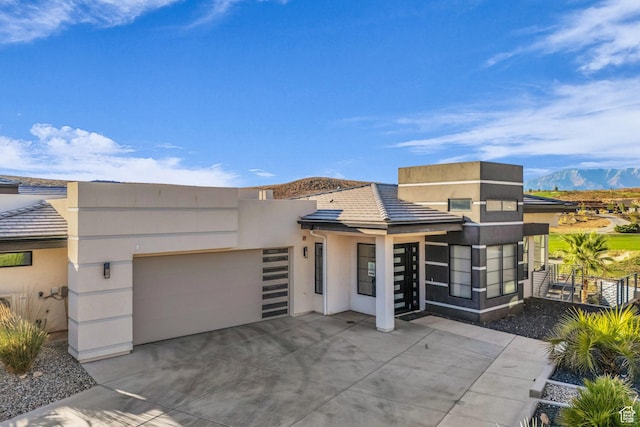 1498 W Torrey Pines Rd, Hurricane, UT 84737 - contemporary house featuring an attached garage, stucco siding, a mountain view, concrete driveway, and fence