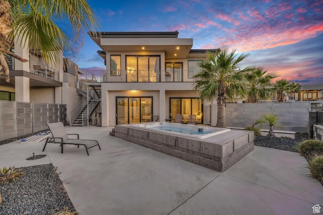 1498 W Torrey Pines Rd, Hurricane, UT 84737 - back of house featuring an outdoor hot tub, stucco siding, a patio area, stairs, and a balcony