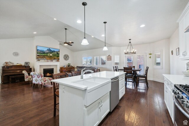 967 W Yamada Ct S, Syracuse, UT 84075 - kitchen with stainless steel appliances, a tile fireplace, light countertops, dark wood finished floors, and vaulted ceiling