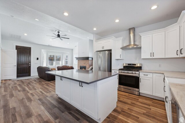 967 W Yamada Ct S, Syracuse, UT 84075 - kitchen featuring stainless steel appliances, wall chimney exhaust hood, a brick fireplace, white cabinetry, and open floor plan