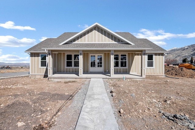view of front of home with a mountain view, covered porch, board and batten siding, and roof with shingles