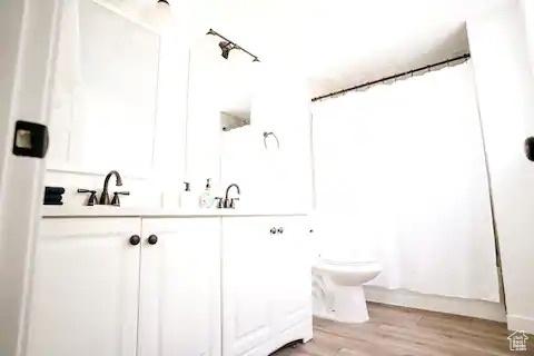1065 E 22nd St, Ogden, UT 84401 - bathroom with toilet, double vanity, and wood finished floors