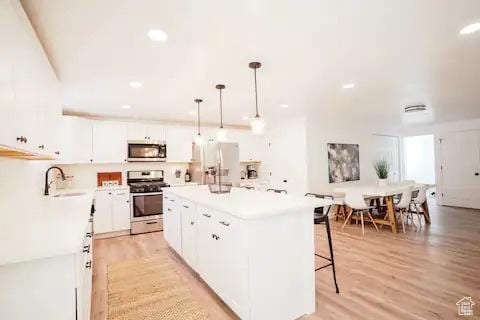 1065 E 22nd St, Ogden, UT 84401 - kitchen featuring stainless steel appliances, a sink, light wood-style floors, white cabinets, and recessed lighting