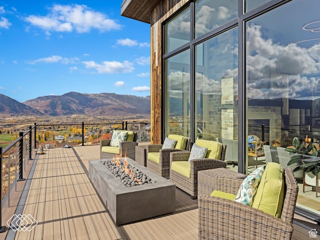 wooden terrace with a mountain view and an outdoor fire pit