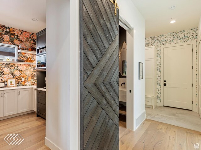 5731 E Porcupine Ridge Dr N, Eden, UT 84310 - hall featuring wallpapered walls, light wood-type flooring, and an accent wall