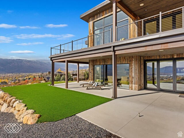 5731 E Porcupine Ridge Dr N, Eden, UT 84310 - back of property with a balcony, a patio, a mountain view, and a yard