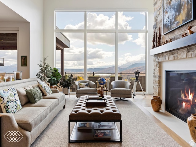 5731 E Porcupine Ridge Dr N, Eden, UT 84310 - living area featuring a mountain view, a large fireplace, wood finished floors, and floor to ceiling windows