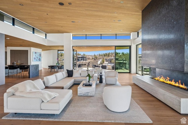 3821 Pinnacle Sky Loop, Park City, UT 84098 - living room featuring wood ceiling, wood finished floors, a high ceiling, and a large fireplace