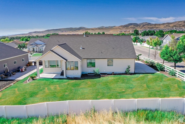 12751 S Harvest Ln W Unit 6, Riverton, UT 84096 - rear view of house with a fenced backyard, a lawn, stucco siding, and a mountain view