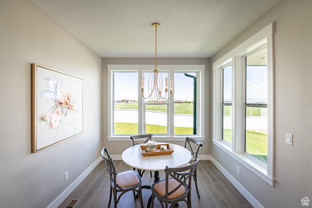12751 S Harvest Ln W Unit 6, Riverton, UT 84096 - dining area featuring dark wood-type flooring, baseboards, a chandelier, and a textured ceiling