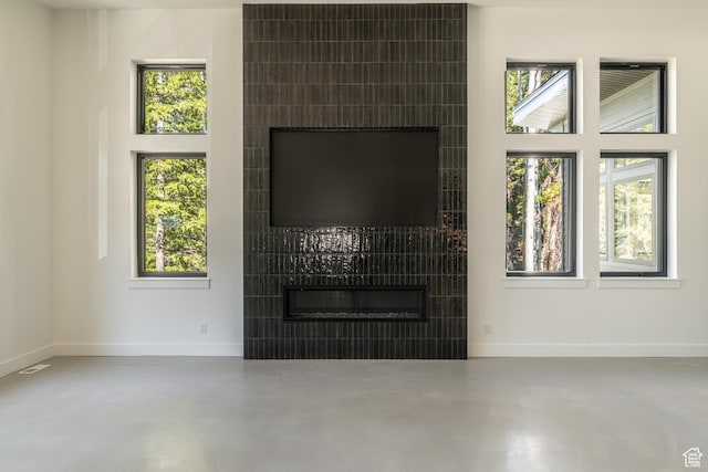 12751 S Harvest Ln W Unit 6, Riverton, UT 84096 - living area featuring baseboards, a tiled fireplace, and finished concrete floors