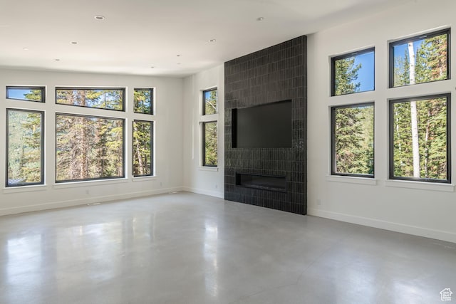 12751 S Harvest Ln W Unit 6, Riverton, UT 84096 - unfurnished living room with finished concrete flooring, baseboards, and a healthy amount of sunlight