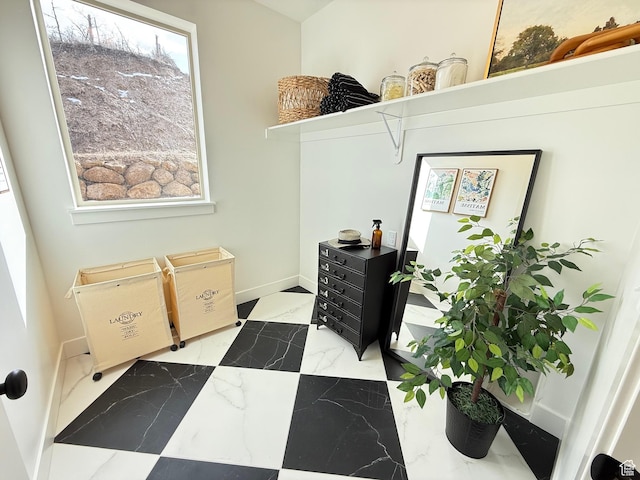 laundry area featuring marble finish floor and baseboards