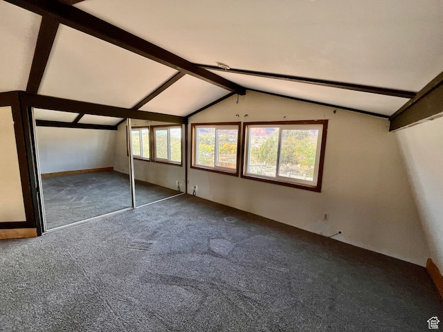 unfurnished bedroom with a closet, carpet, and vaulted ceiling with beams
