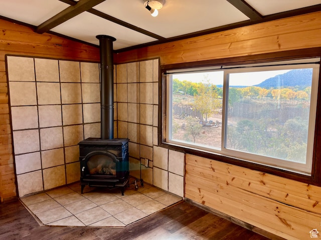details with wooden walls, a wood stove, hardwood / wood-style flooring, and beam ceiling