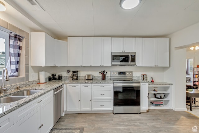 kitchen featuring white cabinetry, appliances with stainless steel finishes, and light hardwood / wood-style floors
