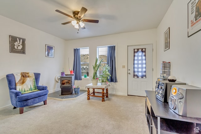 carpeted foyer featuring a wood stove and ceiling fan