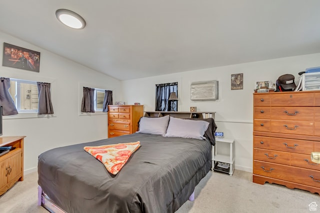 bedroom featuring vaulted ceiling and light colored carpet