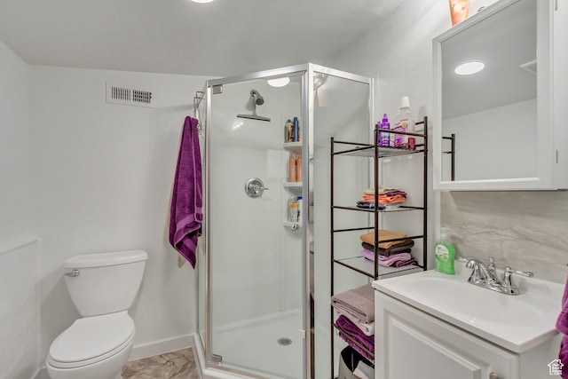 bathroom with toilet, vanity, and an enclosed shower