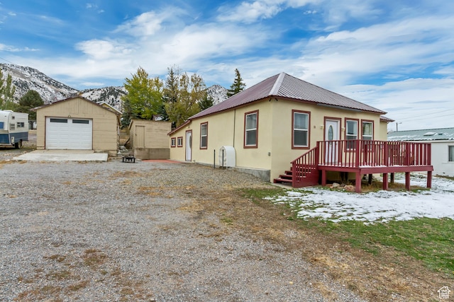 view of front of home featuring an outbuilding, a garage, and a deck with mountain view
