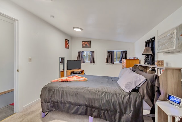bedroom with lofted ceiling, light carpet, and a wall mounted AC