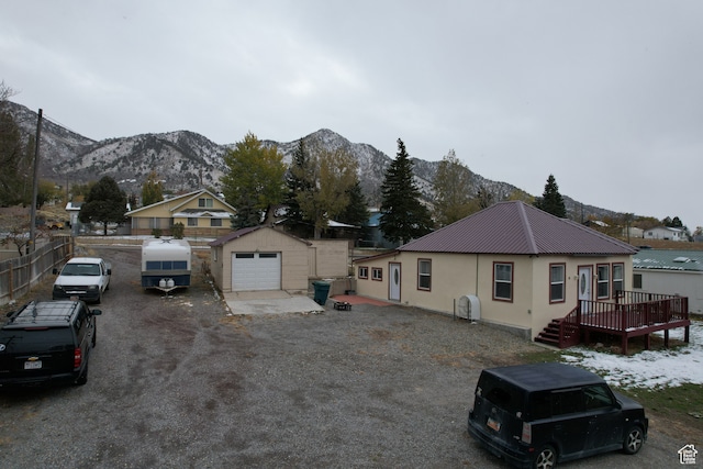 view of front of house with an outbuilding, a garage, and a deck with mountain view