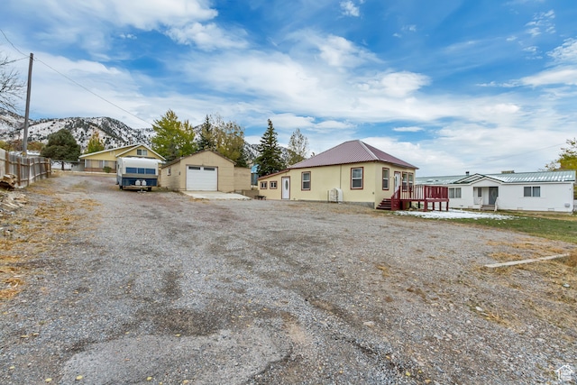 view of front of house featuring a garage, a deck with mountain view, and an outdoor structure