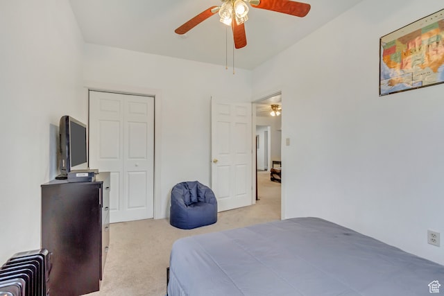 carpeted bedroom featuring radiator heating unit, ceiling fan, and a closet