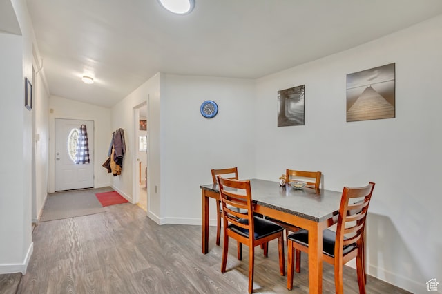 dining room featuring hardwood / wood-style floors and lofted ceiling