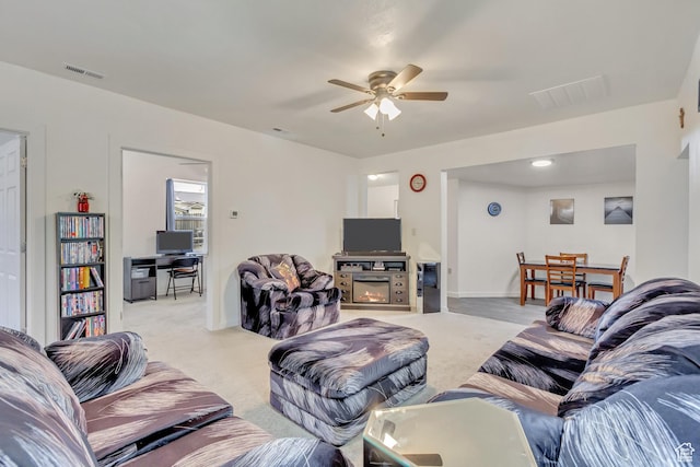 11 W Main St, Eureka, UT 84628 - living room featuring ceiling fan, light colored carpet, a glass covered fireplace, and baseboards