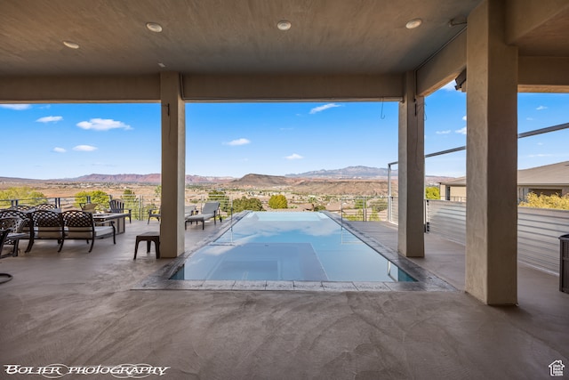 view of swimming pool with a mountain view and a patio area