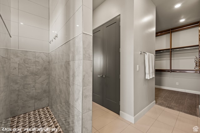 bathroom featuring tile patterned flooring and tiled shower