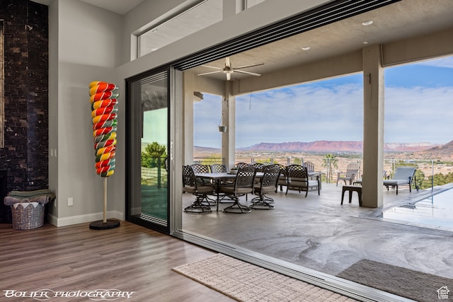 doorway to outside with wood-type flooring, a mountain view, and ceiling fan