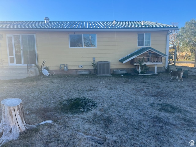 rear view of house featuring central AC, entry steps, metal roof, and crawl space