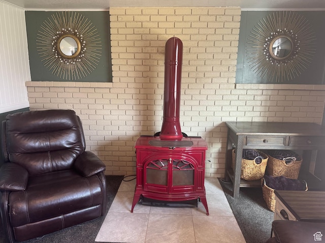living area with ornamental molding, a wood stove, and tile patterned flooring