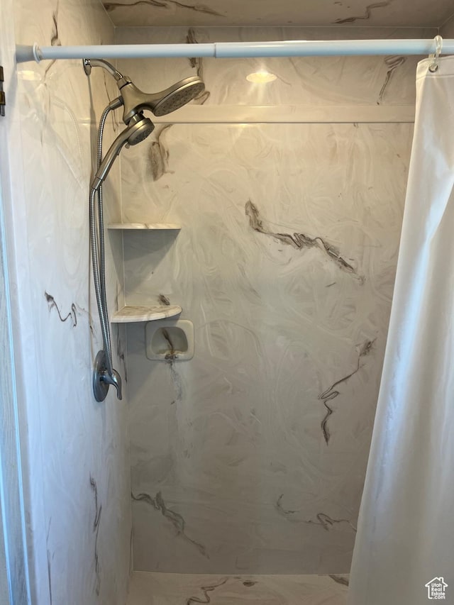 bathroom with a marble finish shower