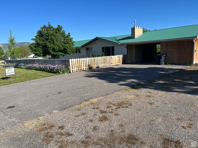 290 W 500 S, Manti, UT 84642 - view of front of house with a chimney, asphalt driveway, metal roof, and an attached carport