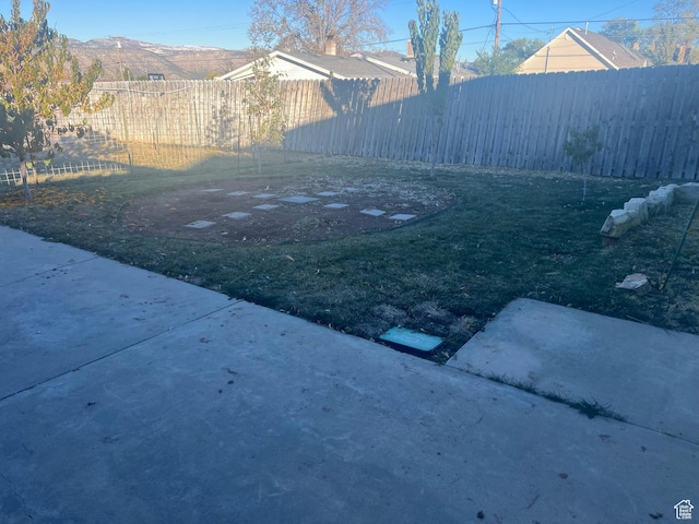view of yard with a patio, a mountain view, and fence