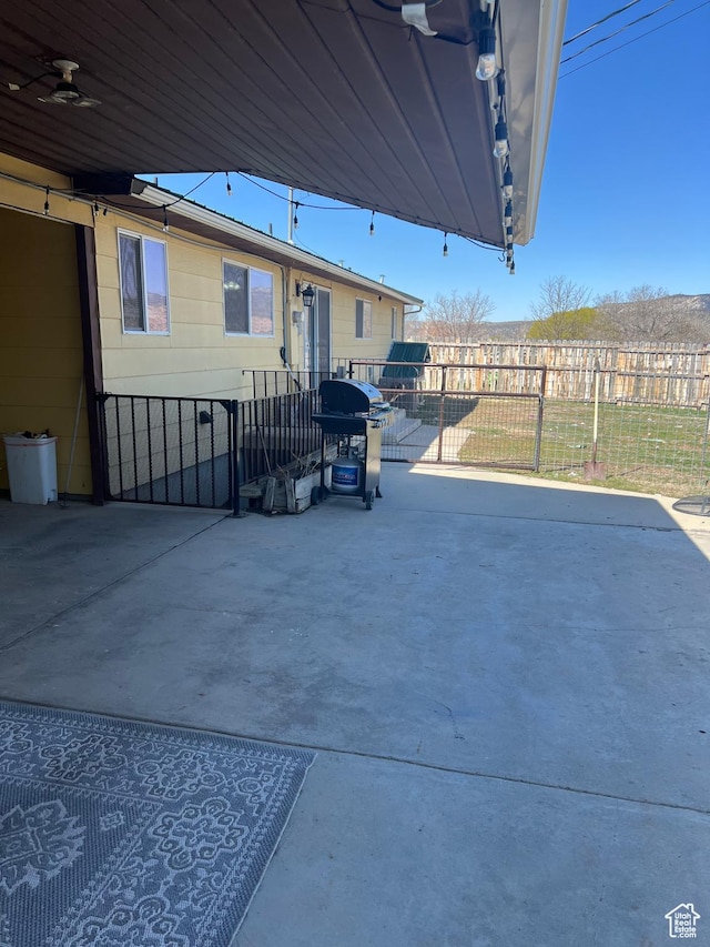view of patio featuring fence and a grill
