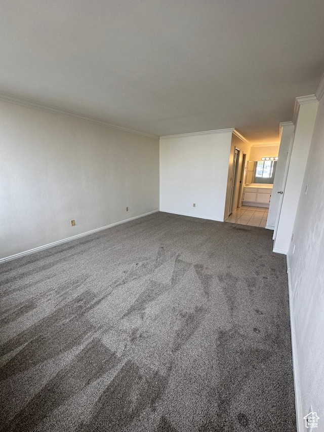 carpeted empty room with crown molding and baseboards