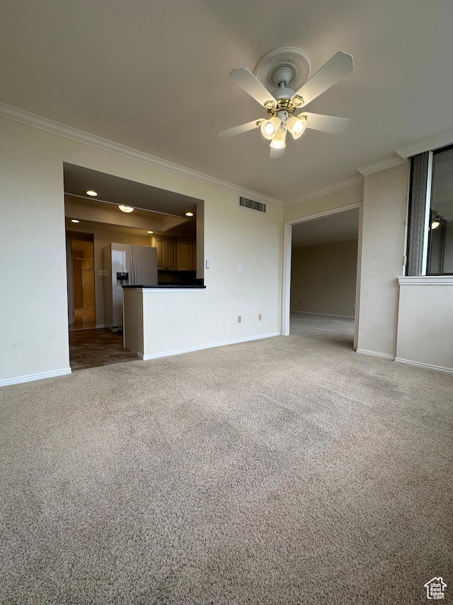 unfurnished living room with ornamental molding, ceiling fan, baseboards, and carpet