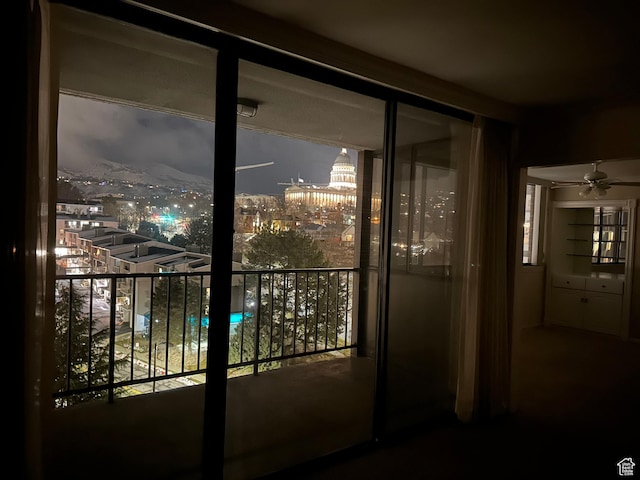 doorway to outside featuring ceiling fan and a view of city lights
