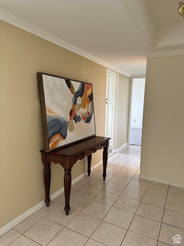 corridor featuring light tile patterned flooring, crown molding, and baseboards