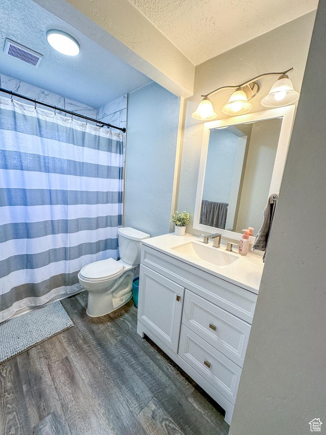 772 W 4375 S, Riverdale, UT 84405 - bathroom with wood finished floors, vanity, toilet, a textured ceiling, and a shower with curtain