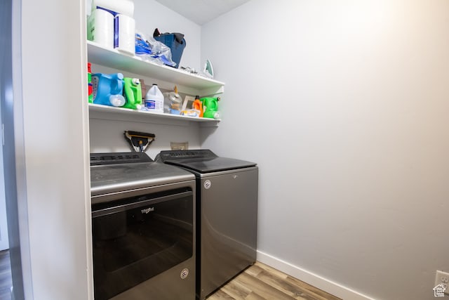 washroom with washing machine and dryer and light wood-type flooring