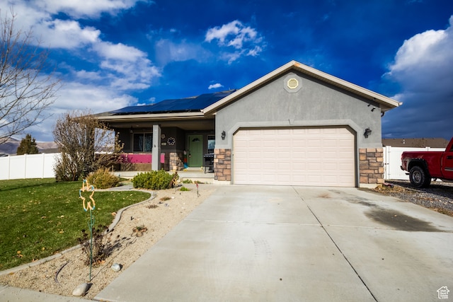 ranch-style house with covered porch, solar panels, a garage, and a front lawn