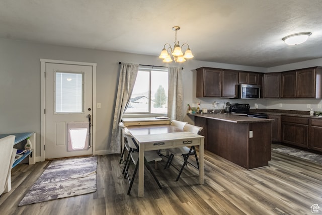 kitchen with dark brown cabinets, hardwood / wood-style flooring, an inviting chandelier, decorative light fixtures, and black range with electric stovetop