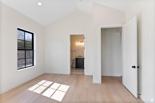 231 S Wiltshire Ln, Saratoga Springs, UT 84045 - unfurnished bedroom with light wood-style floors, vaulted ceiling, baseboards, ensuite bathroom, and a sink